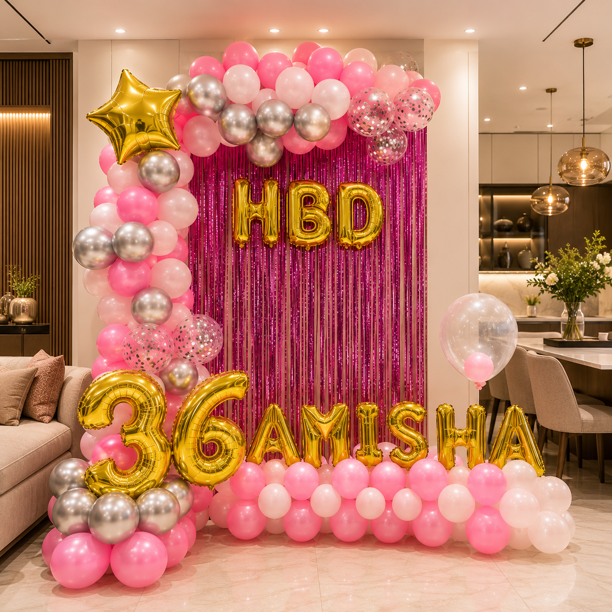 Decorative balloon arch with 'HBD 36 AMISHA' text in a room setting.