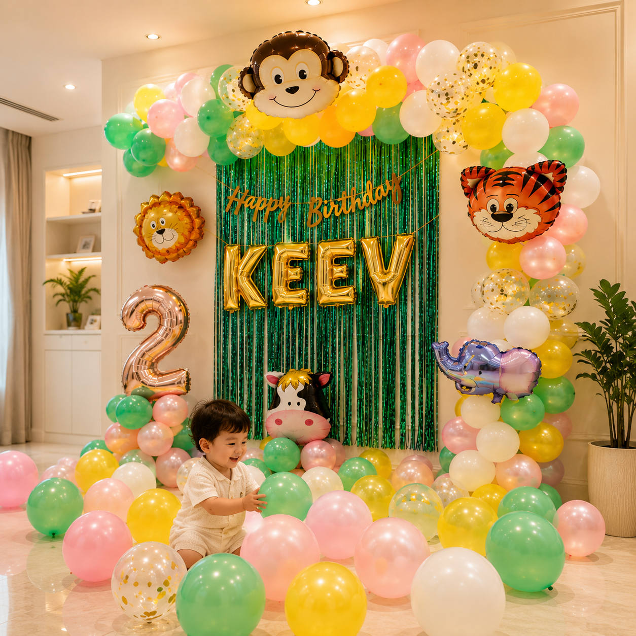 Child in a room decorated with colorful balloons and a 'Happy Birthday Keev 2' sign.