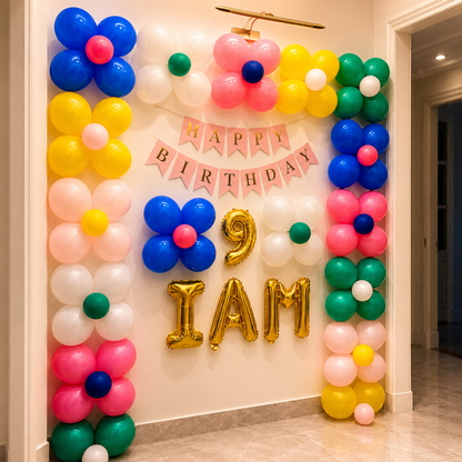 Colorful balloon arch with 'Happy Birthday' banner and number balloons on a wall.