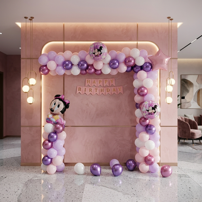 Pink birthday arch with balloons and Minnie Mouse decorations in a room.