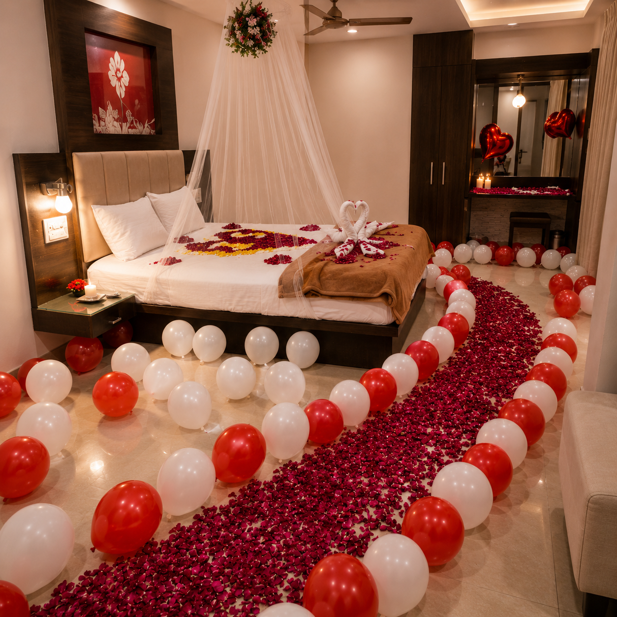 Decorated bedroom with balloons, rose petals, and a heart-shaped arrangement on the bed.