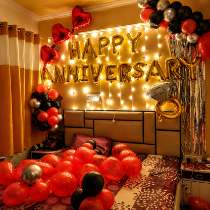 Decorated room with 'Happy Anniversary' balloons and lights on a wall.