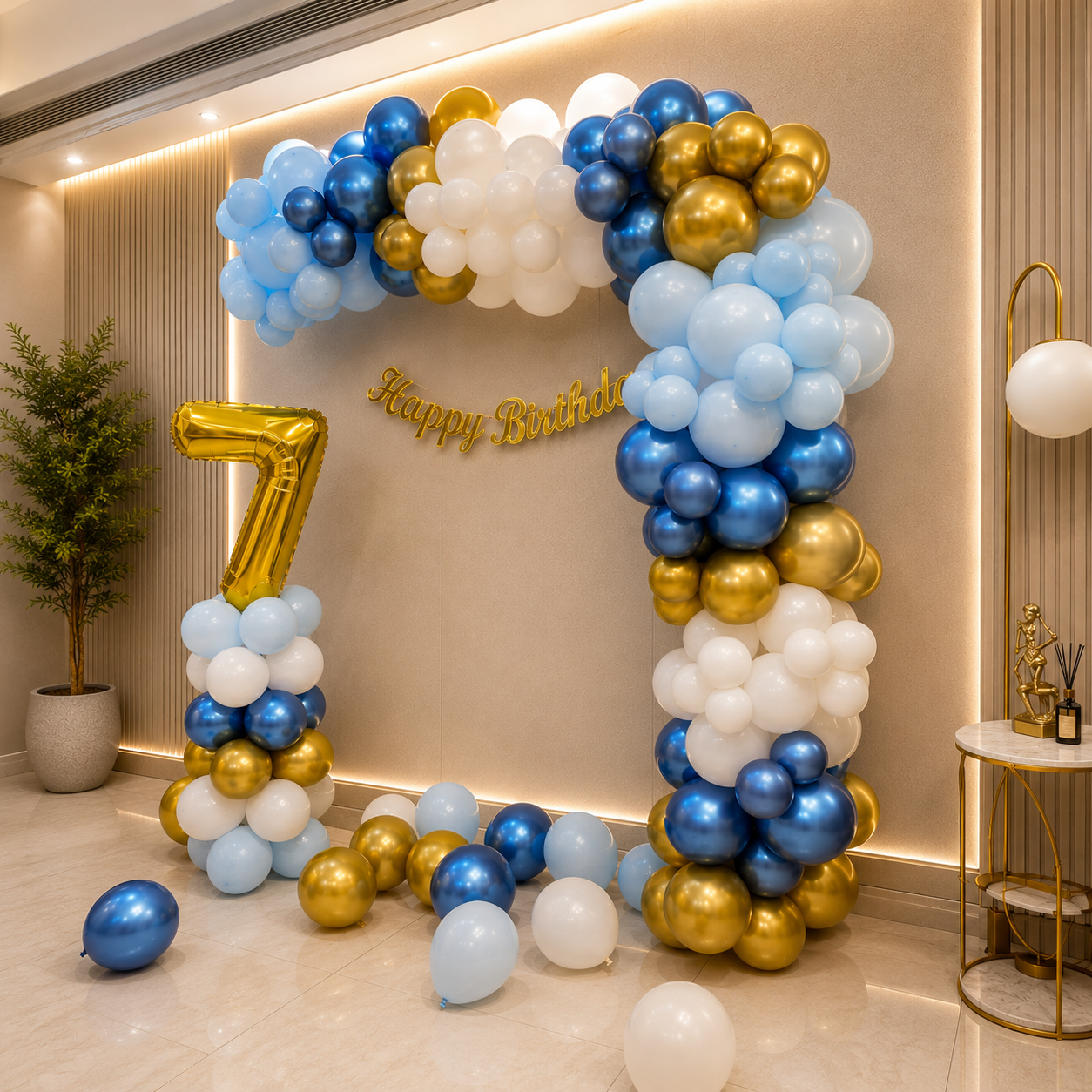 Balloon arch with blue, gold, and white balloons and a gold number 7 in a room.