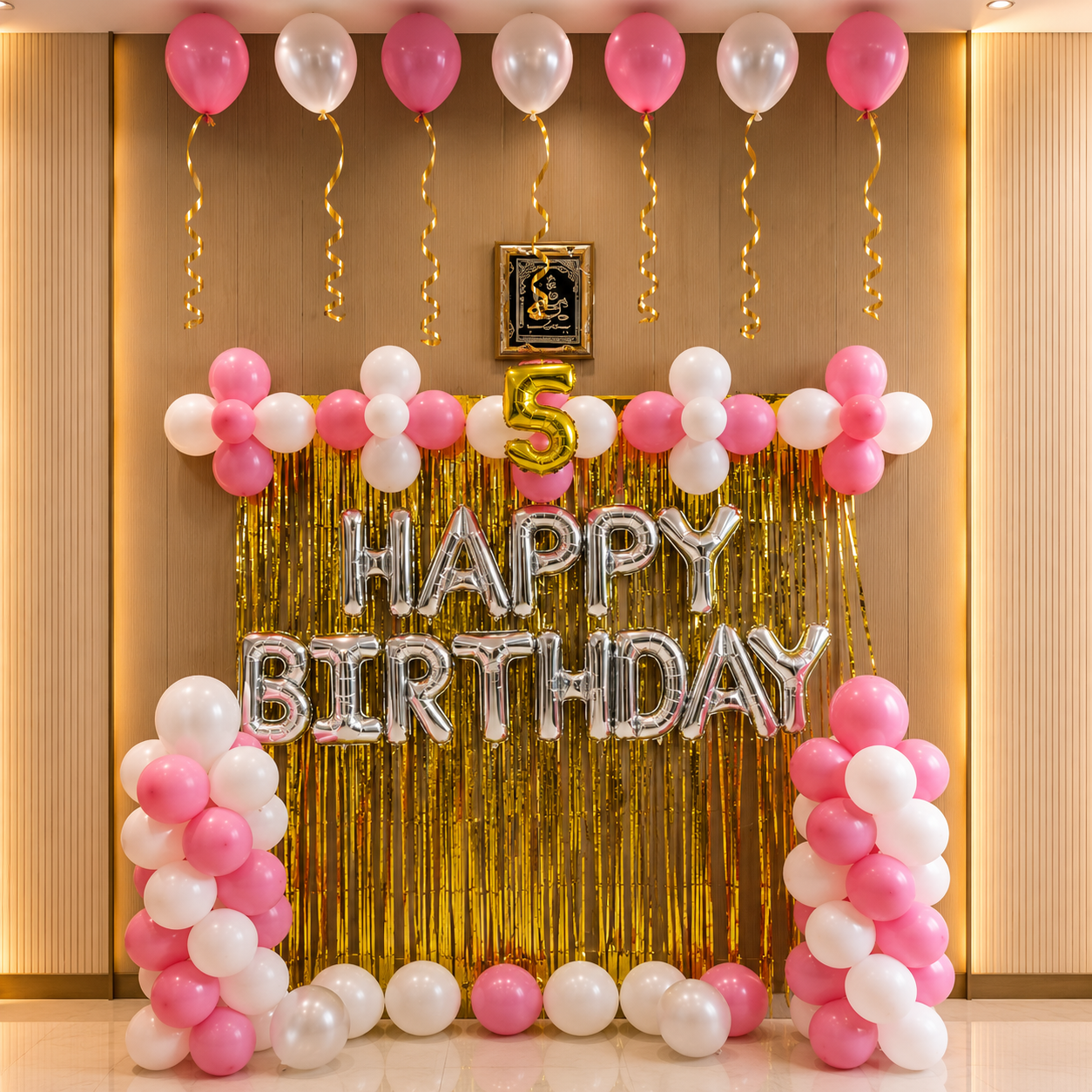 Birthday decoration with balloons and 'Happy Birthday' banner on a wall.