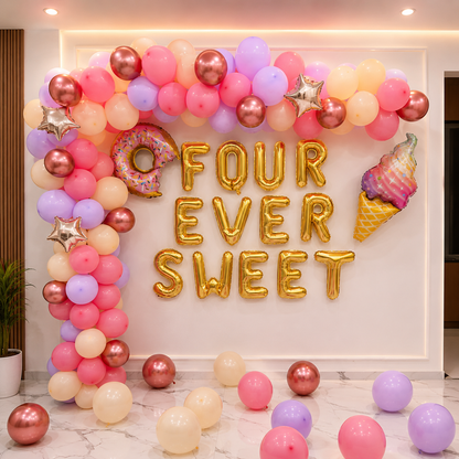 Decorative balloon arch with 'FOUR EVER SWEET' text and balloons on a wall.