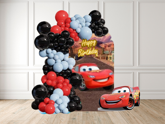 Balloon arch with Disney Cars theme in a room with white paneled walls.