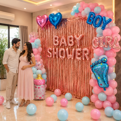 Pregnant couple standing in front of a 'Baby Shower' backdrop with pink and blue balloons.