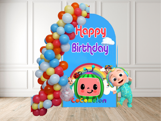 Cocomelon birthday banner with colorful balloons against a white wall.