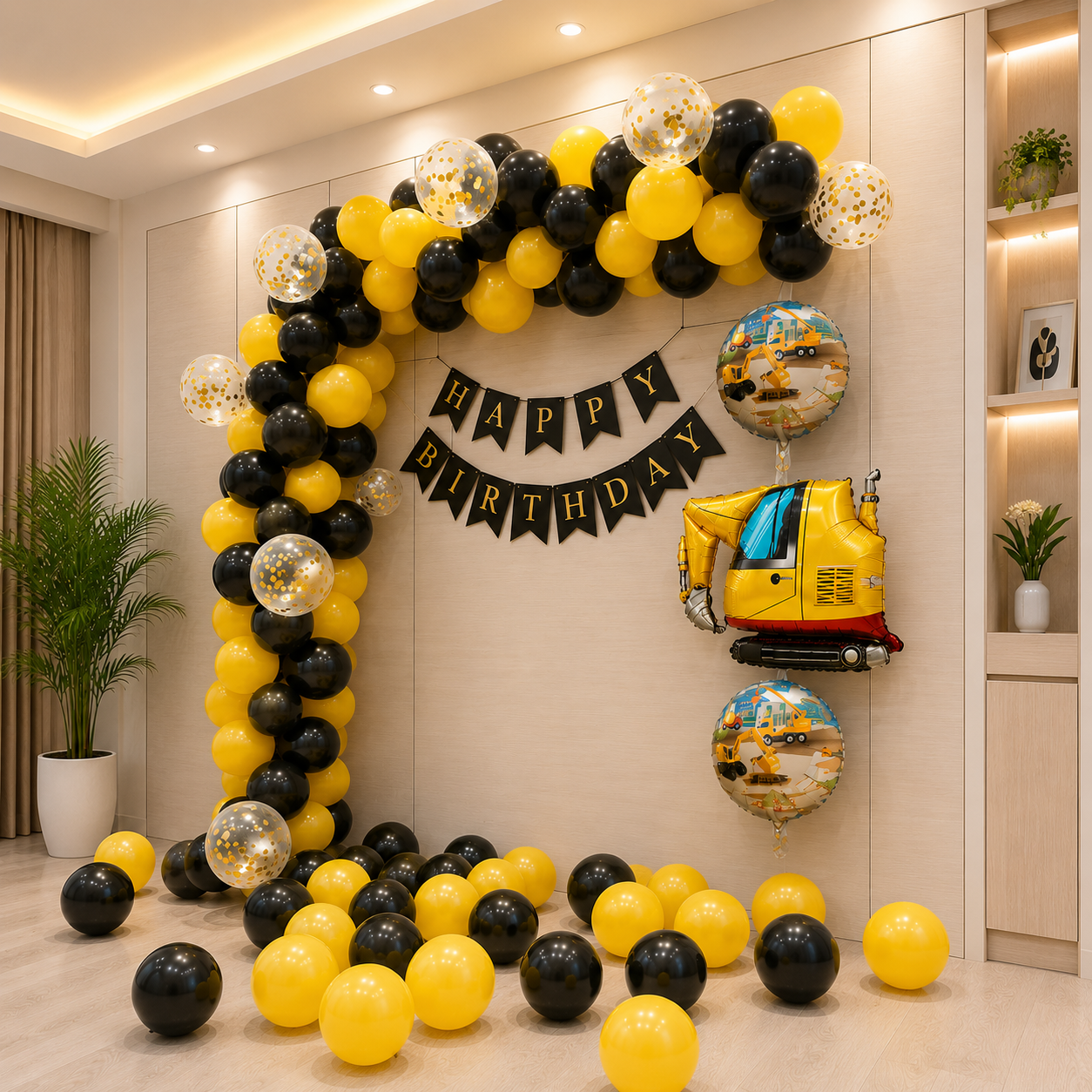 Birthday balloon arch with yellow, black, and gold balloons, 'Happy Birthday' banner, and construction-themed balloons in a room.