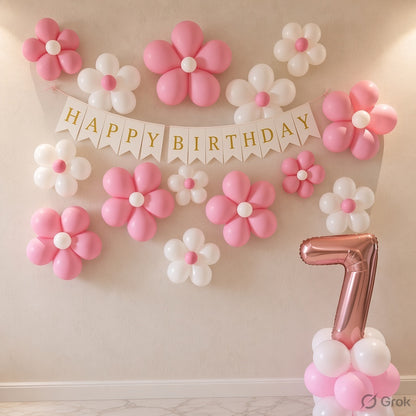 Pink and white balloon flower decorations arranged on a beige wall, with a white 'HAPPY BIRTHDAY' banner and a metallic rose-gold number 7 balloon at the bottom right.