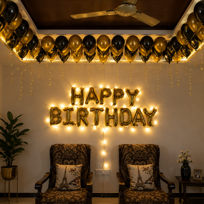 Decorated room with 'Happy Birthday' balloons and string lights, chairs with Eiffel Tower pillows, and a ceiling fan.