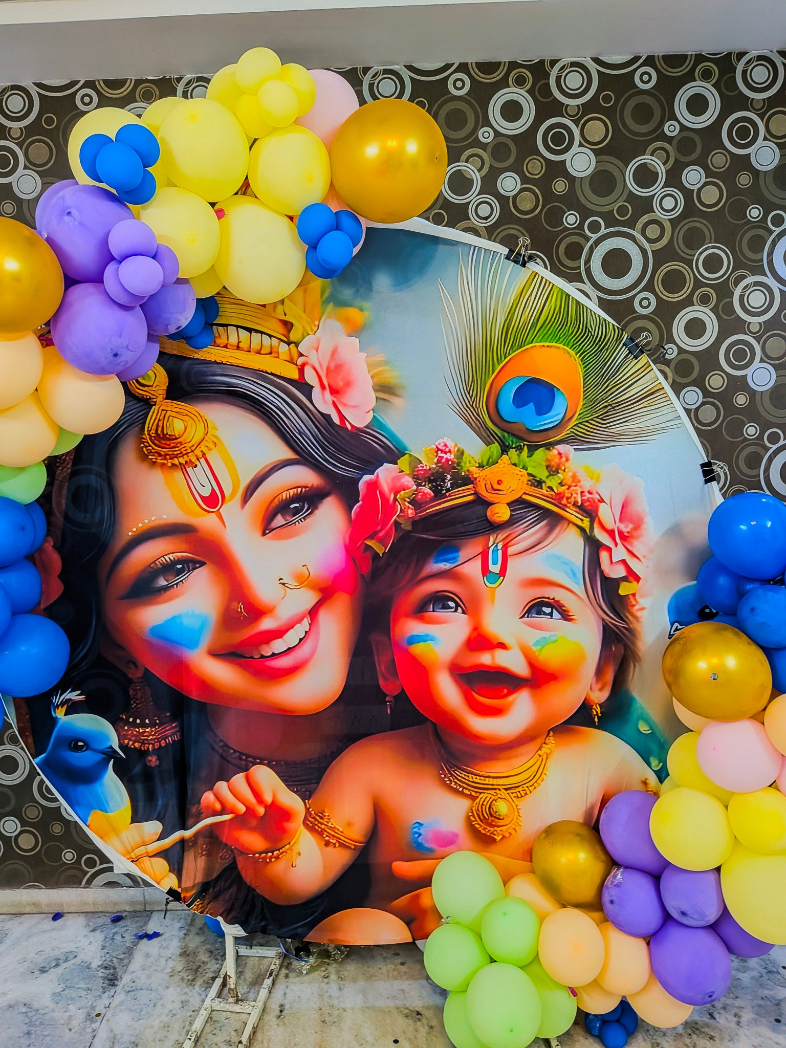 Decorative photo frame with colorful balloons and a picture of a woman and child with face paint.