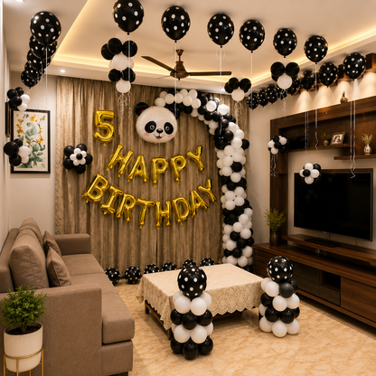 Living room decorated with black, white, and gold balloons for a 5th birthday celebration.