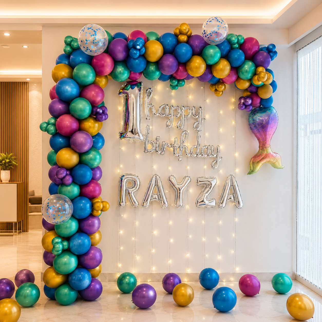 Colorful balloon arch with 'Happy Birthday RAYZA' text in a room.