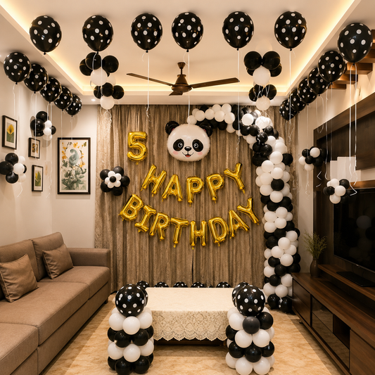 Living room decorated with black, white, and gold balloons for a 5th birthday celebration.