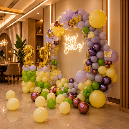 Colorful balloon arch with 'Happy Birthday' and number '29' in a decorated room.