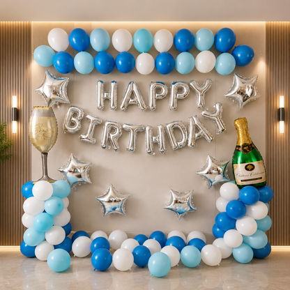 Birthday decoration set with balloons, 'Happy Birthday' banner, and champagne bottle on a wall.