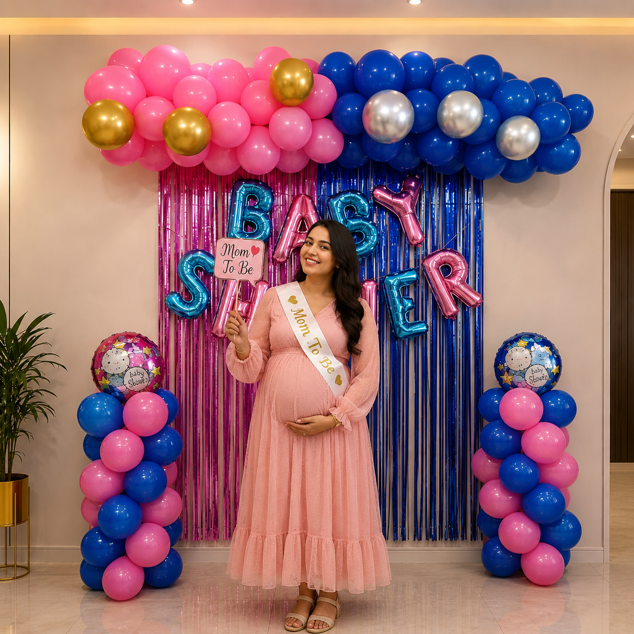 Woman in a pink dress standing in front of a baby shower decoration with balloons and streamers.