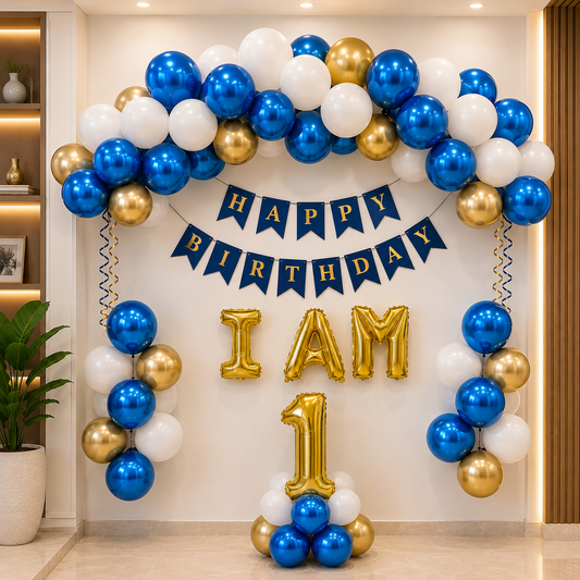 Balloon arch with 'Happy Birthday' banner and 'I am 1' gold balloons in a room setting.