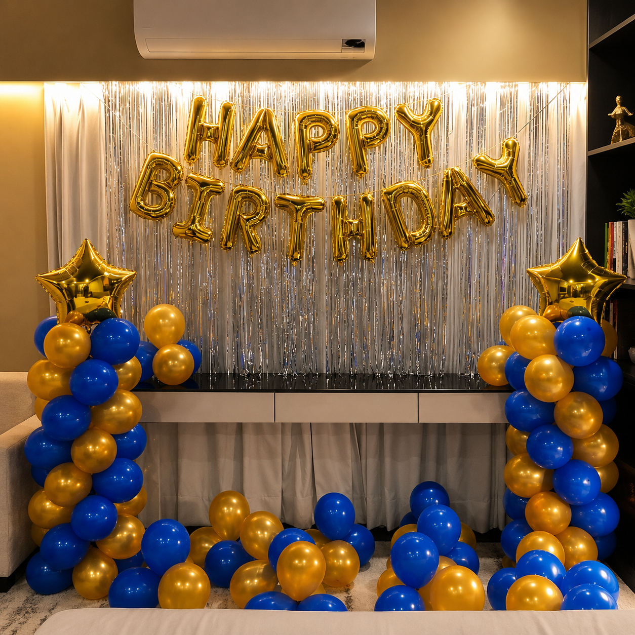 Birthday celebration setup with gold, blue, and yellow balloons and 'Happy Birthday' balloons.