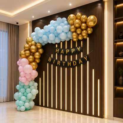 Balloon arch with 'Happy Birthday' banner against a dark wall with vertical lights