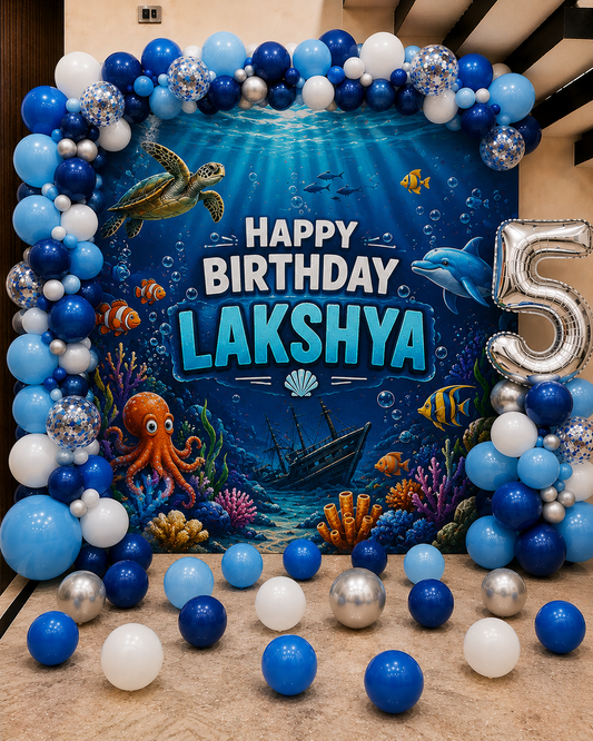 Underwater-themed birthday decoration with balloons and 'Happy Birthday Lakshya' sign.