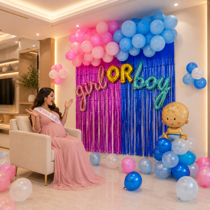 Woman in a pink dress with a 'Mommy to be' sash, surrounded by gender reveal balloons and decorations.